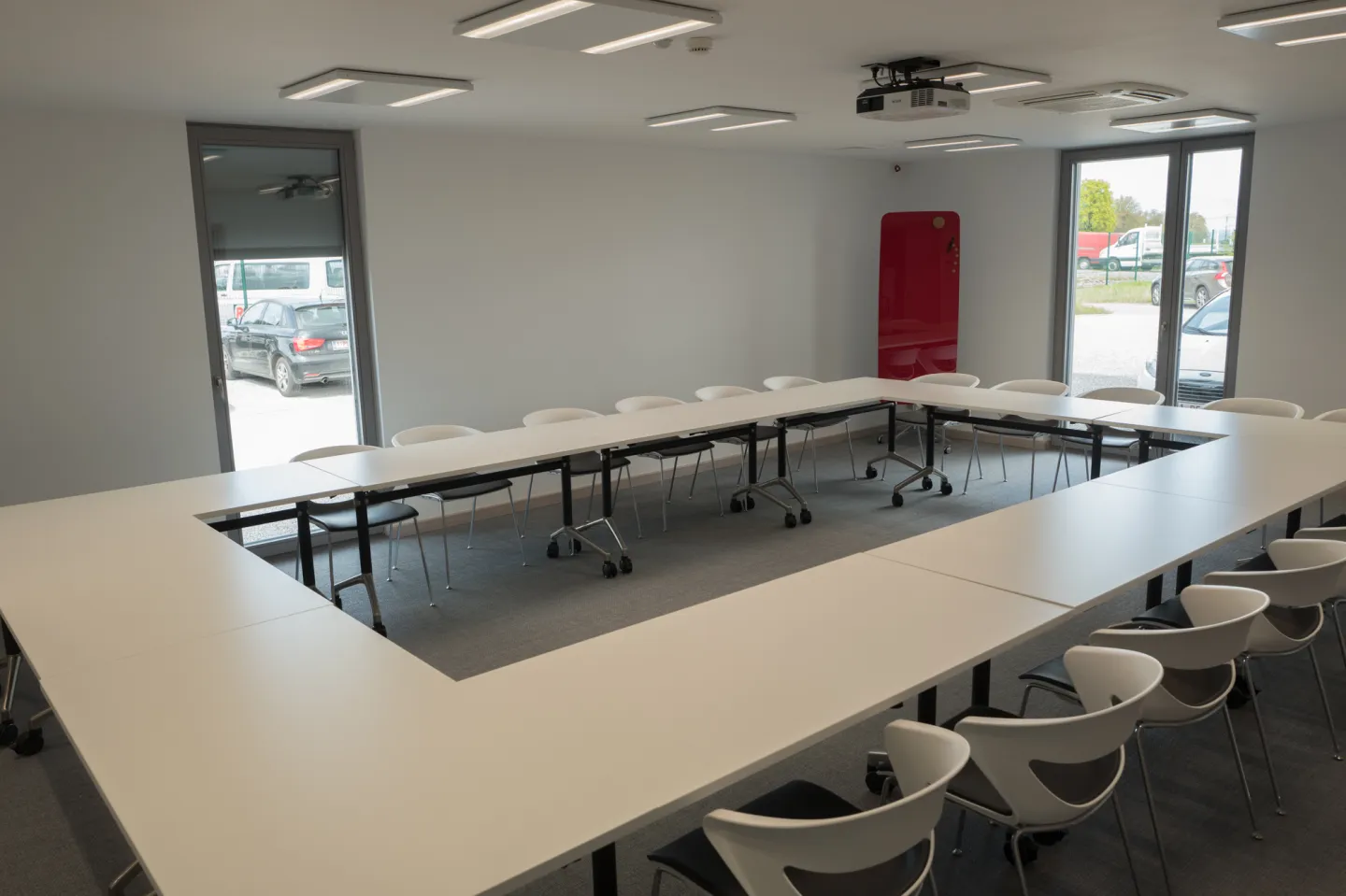 Salle de conférence pour 30 personnes avec projecteur, tables en U